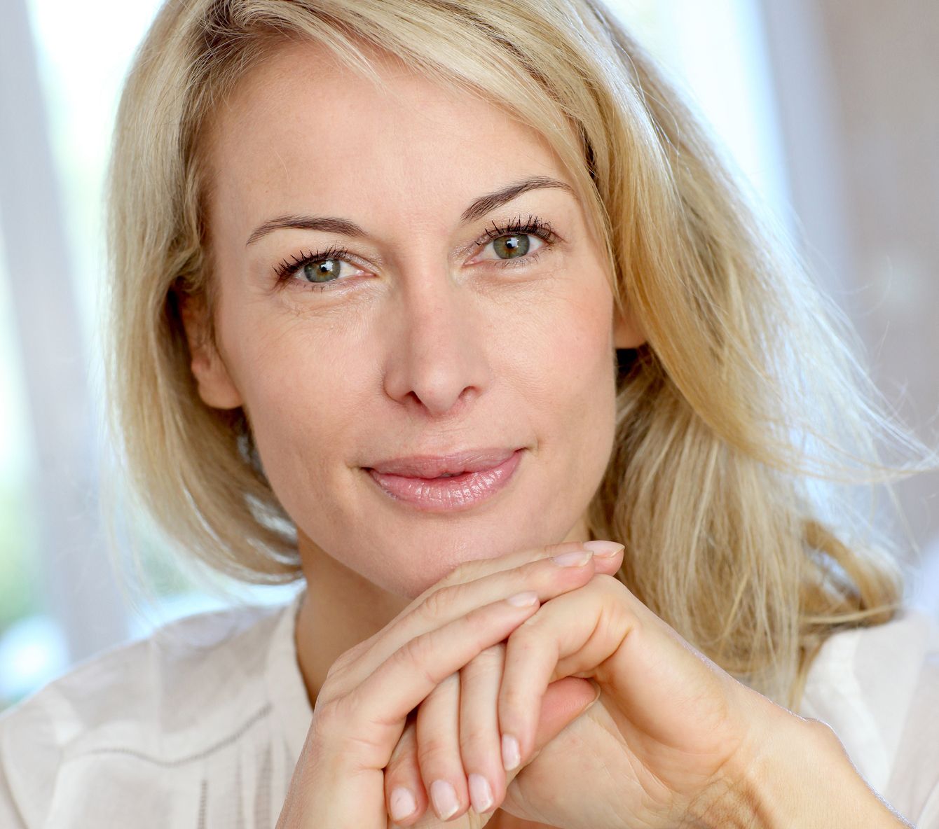 Smiling woman with blonde hair and soft features.